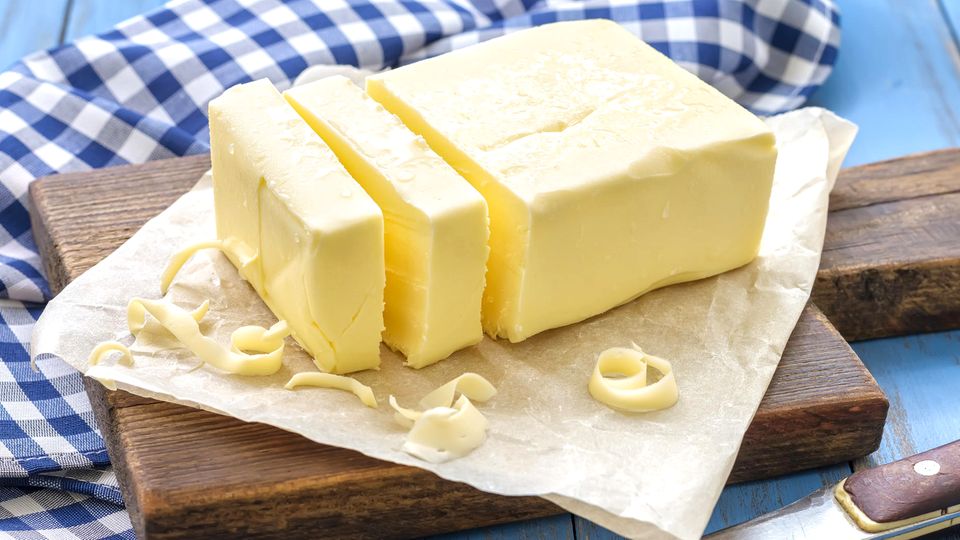 Ein Block Butter auf einem Holzbrett