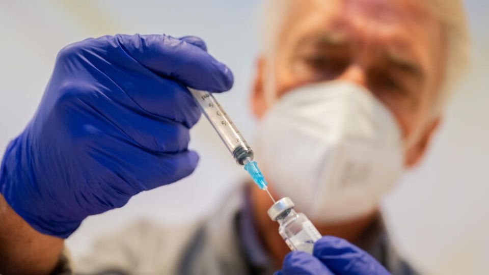 Ein Mann bereitet eine Corona-Impfung vor