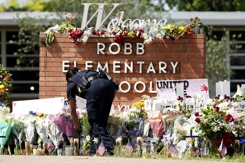 Eine Polizistin legt Blumen vor der Robb Elementary School in Uvalde nieder