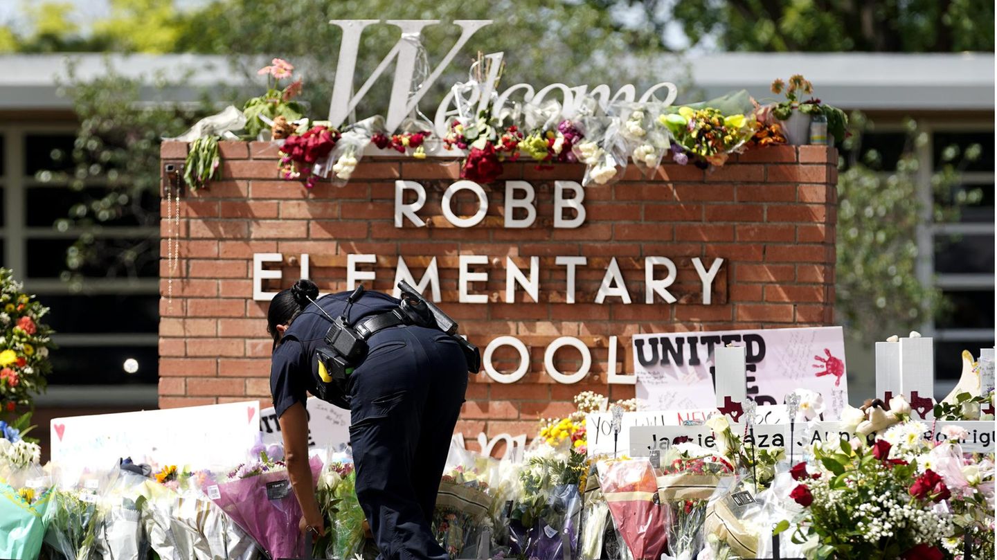Eine Polizistin legt Blumen vor der Robb Elementary School in Uvalde nieder