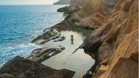 Alter Sandsteinbruch und mythische Bucht. Mit den hier abgebauten Steinen sollen die Mauern des Weltkulturerbes Dalt Vila in Ibiza Stadt erbaut worden sein. Stellen Sie sich auf eine schweißtreibende 35-minütige Wanderung ohne Wegweiser über Felsen, Baumwurzeln und Sanddünen ein, nehmen Sie genug Trinkwasser mit, und tragen Sie feste Schuhe. Die Mühe lohnt sich, vor allem wenn man am späten Nachmittag kommt, um sich den hinreißenden, flammenden Sonnenuntergang über Es Vedrà anzusehen.  Wegbeschreibung: Von Sant Josep de sa Talaia auf der PMV-803-1 für 7,3 km Richtung Süd- westen, rosa Wegweiser zum Torre des Savinar links. Nach 450 m auf der unbe- festigten Straße irgendwo parken. Dem ausgeschilderten Weg nach Sa Pedrera de Atlantis bis zum Klippenrand folgen. Von hier führen mehrere Wege nach unten.  Erreichbarkeit: Schwer 35 Min