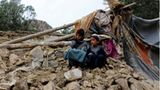 Zwei Jungen sitzen in der Nähe ihres Hauses, das bei einem Erbeben zerstört wurde
