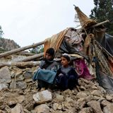 Zwei Jungen sitzen in der Nähe ihres Hauses, das bei einem Erbeben zerstört wurde