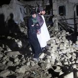 Afghanen in den Ruinen ihrer Häuser