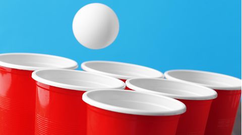 Beer-Pong-Luftmatratze: Ein Tischtennisball fliegt in die roten Trinkbecher.