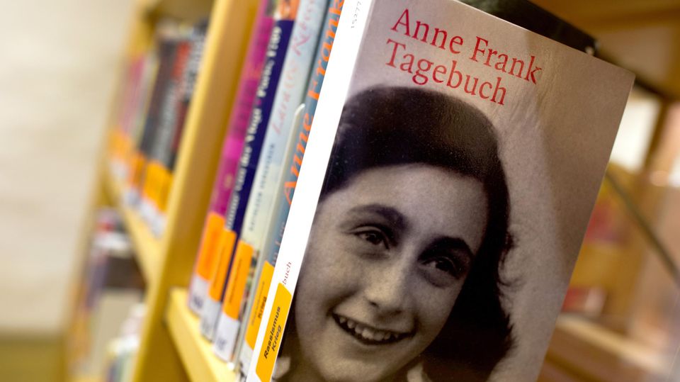 In einem Bücherregal einer Bibliothek steht eine Ausgabe von Anne Franks Tagebuch