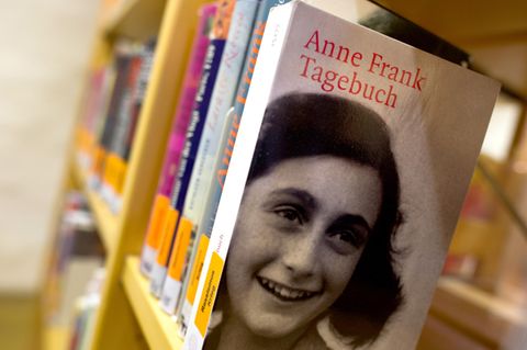 In einem Bücherregal einer Bibliothek steht eine Ausgabe von Anne Franks Tagebuch
