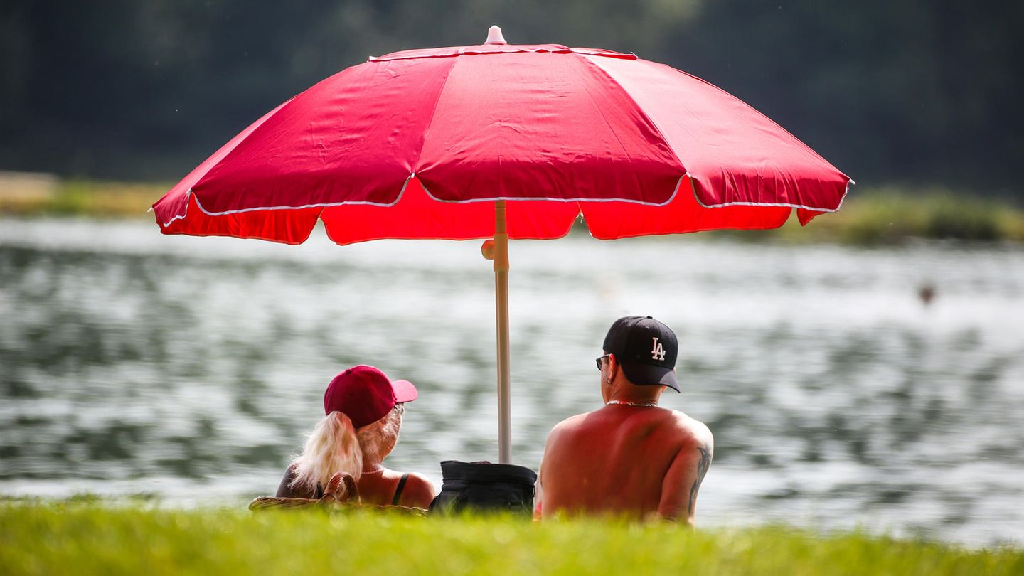 Hitze in Deutschland: Menschen schützen sich im Schatten vor der Sonne