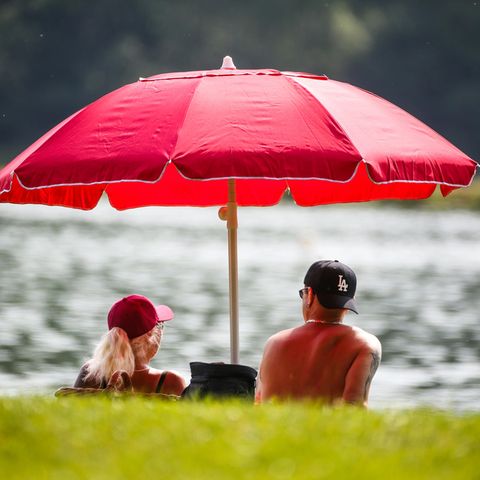 Hitze in Deutschland: Menschen schützen sich im Schatten vor der Sonne