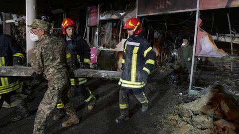 Krementschuk, Ukraine. Feuerwehrleute nach einem Raketenangriff auf ein Einkaufszentrum