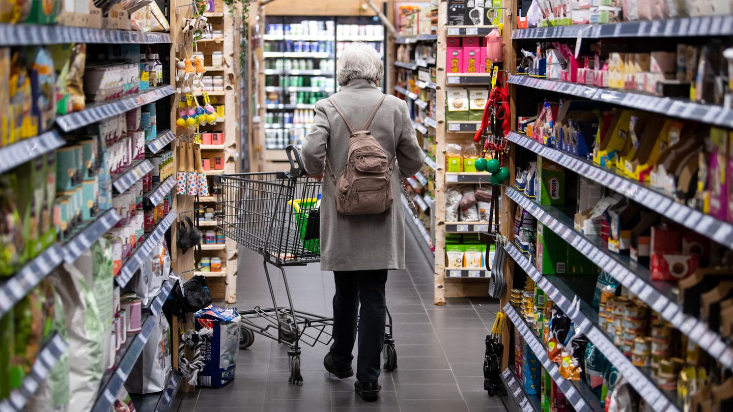 Frau läuft durch einen Supermarkt.