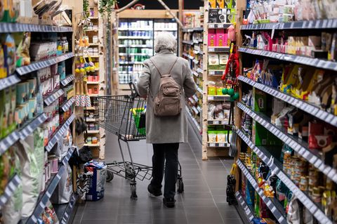 Frau läuft durch einen Supermarkt.