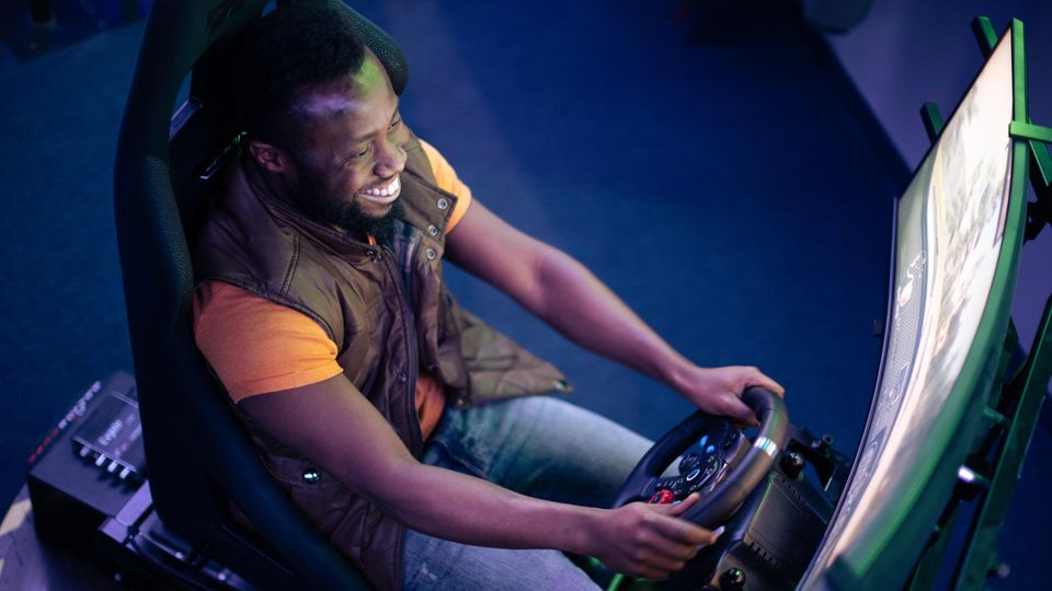 Ein Mann spielt am Curved-Monitor mit 34 Zoll Bildschirmdiagonale.