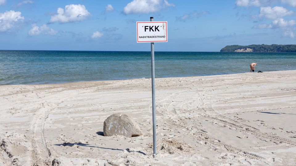 FKK-Strand in Binz auf Rügen mit einem nackten Mann im Hintergrund