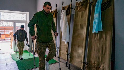 Ukrainische Soldaten mit Krücken, die während des Krieges gegen Russland verwundet wurden, betreten ein Militärkrankenhaus