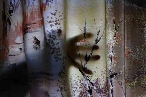 Hand hinter Vorhang