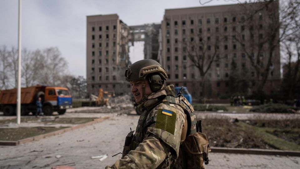 Ein Soldat der Ukraine sichert nach einem russischen Angriff im März auf Mykolajiw den Ort der Attacke.