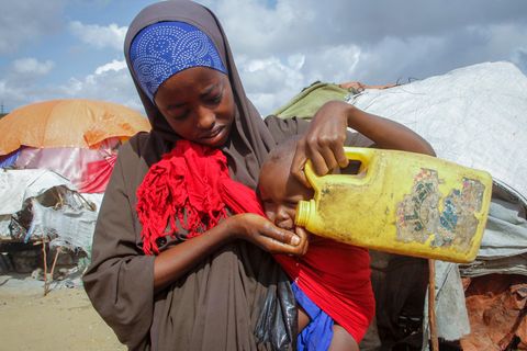 Eine Frau gibt ihrem Kind in einem Flüchtlingslager am Rand der somalischen Hauptstadt Mogadischu Wasser. Dürren und Preisexplosionen bedrohen das Leben von mehreren Millionen Menschen am Horn von Afrika