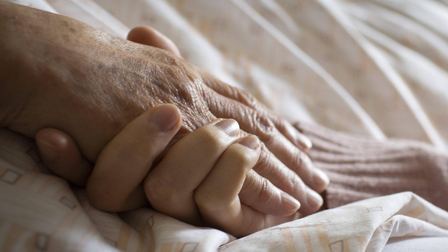 Eine junge Hand umfasst eine alte Hand