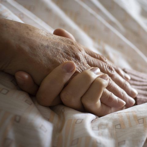 Eine junge Hand umfasst eine alte Hand