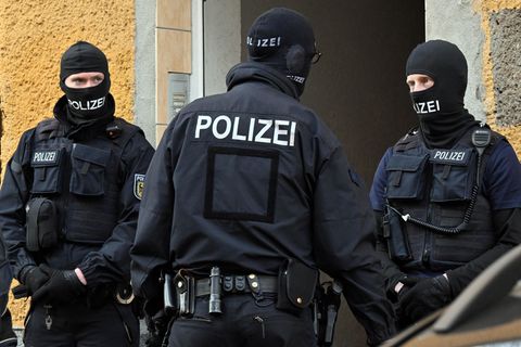Bundespolizisten stehen vor einem Hauseingang