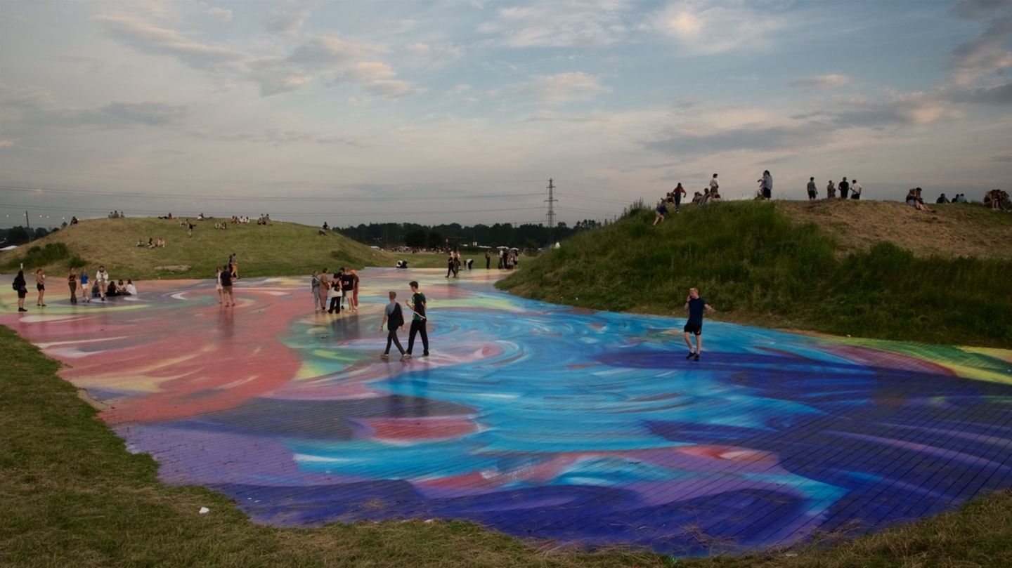 Ein riesiger psychedelischer Dancefloor der Künstlerin Katharina Grosse in den Hügeln oberhalb der "Dream City" – eines von vielen Kunstprojekten auf dem Roskilde-Festival 2022
