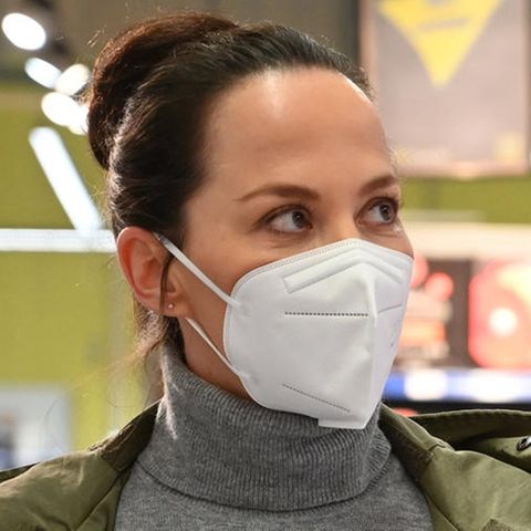 Eine Frau trägt in einem Mund-Nasenschutz beim Einkaufen.