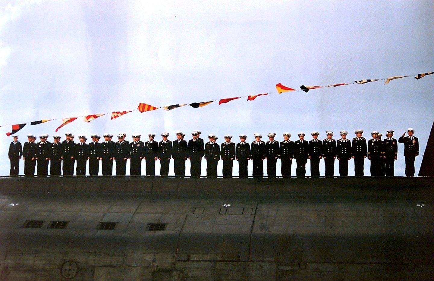 Tragödie auf dem Grund des Meeres Doch die hoffnungslose Stimmung im Land, die Putins Wahl auslöst, verfliegt schnell. Am 12. August 2000 sinkt eins der größten und modernsten russischen Atom-U-Boote: K-141, auch als "Kursk" bekannt. Das U-Boot befindet sich am Unglückstag für einem Seemanöver in der Barentssee. Dann bricht der Funkkontakt plötzlich ab. Erst zwölf Stunden später beginnt die Suche nach U-Boot K-141. Über das, was danach geschieht, kann nur spekuliert werden. Die neue russische Regierung behauptet zunächst, die "Kursk" sei von einem US-amerikanischen U-Boot gerammt worden. Bergungsspezialisten, unter ihnen norwegische Taucher, untersuchen jedoch eine Woche nach dem Unglück das Wrack und stellten fest: Zwei Explosionen im Bug haben das U-Boot versenkt. Die norwegischen Taucher waren es auch, die die die Notluke öffnen. Sie finden aber keine Überlebenden mehr. Norwegen hat bereits zwei Tage nach Verlieren des Funkkontakts seine Hilfe angeboten. Moskau lehnte aber ab. Von der 118 Mann starken Besatzung überlebt niemand. Dieses Bild vom 30. Juli 2000 zeigt einige der Marinesoldaten auf der "Kursk", wenige Tage vor ihrem Tod. Im Abschlussbericht der Regierungskommission heiß es schließlich, ein defekter Torpedo habe an Bord eine Kettenreaktion aus Explosionen ausgelöst und die Katastrophe verursacht. Weitere Informationen des Berichts sollen aus vermeintlichen Sicherheitsgründen für 25 Jahre geheim bleiben.