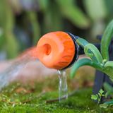 Gartenarbeit im Juli: Nahaufnahme eines verstellbaren Tropfkopfes in einem Pflanztopf