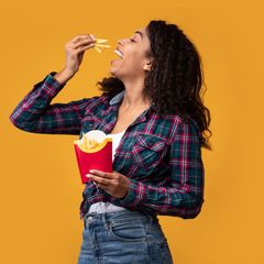 Eine Frau genießt knusprige Pommes