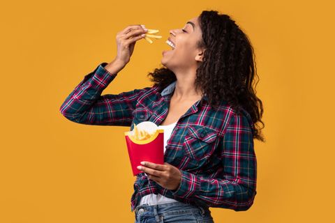Eine Frau genießt knusprige Pommes
