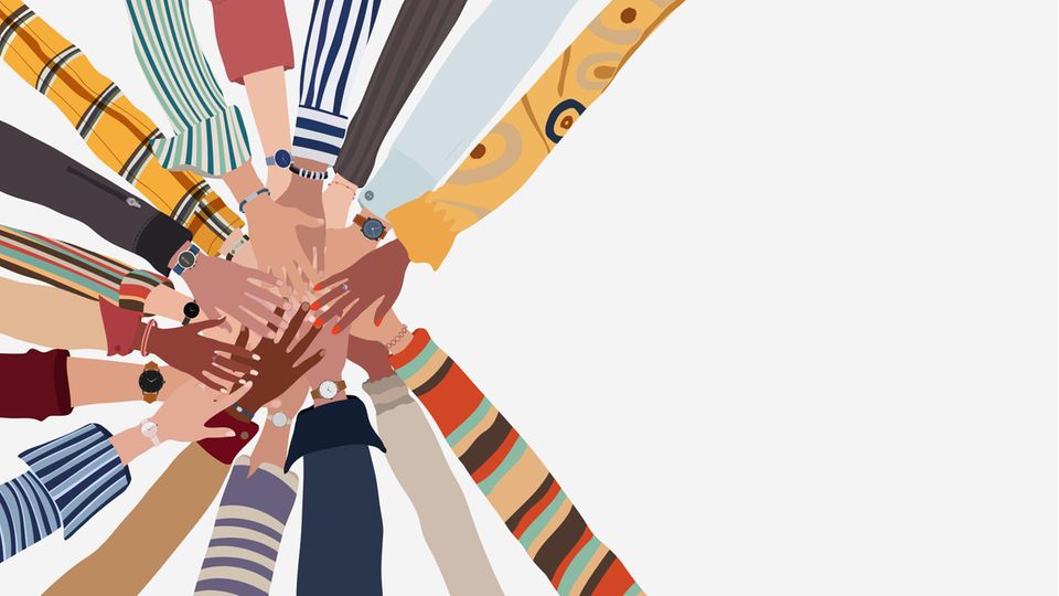 Gruppe von Händen übereinander in einem Kreis von Menschen unterschiedlicher Kultur und Rasse