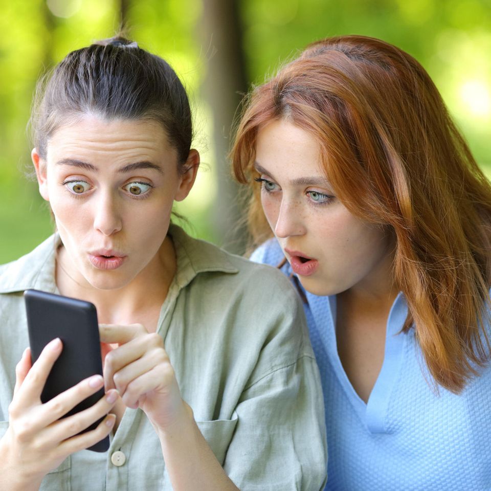 Zwei Frauen schauen geschockt auf ein Smartphone