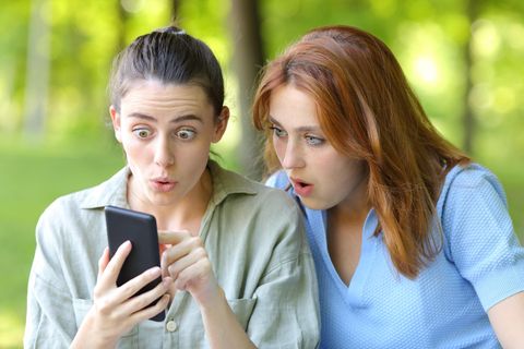 Zwei Frauen schauen geschockt auf ein Smartphone