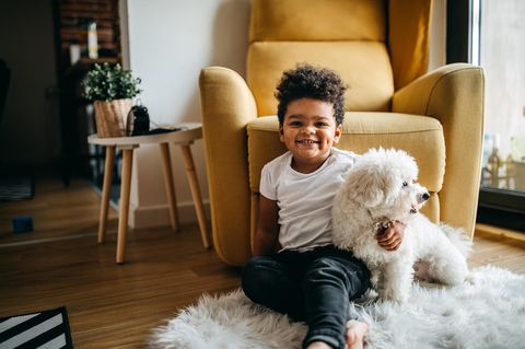 Ein kleiner Junge umarmt einen Hund