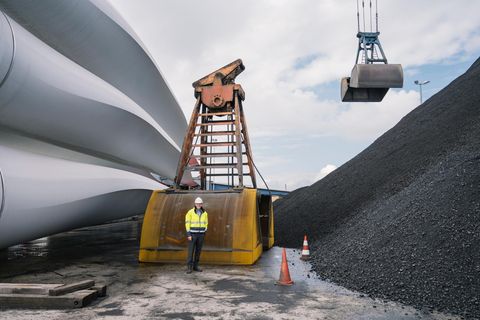 Frank Schnabel zwischen Windkraftrotoren und Kohlehalde