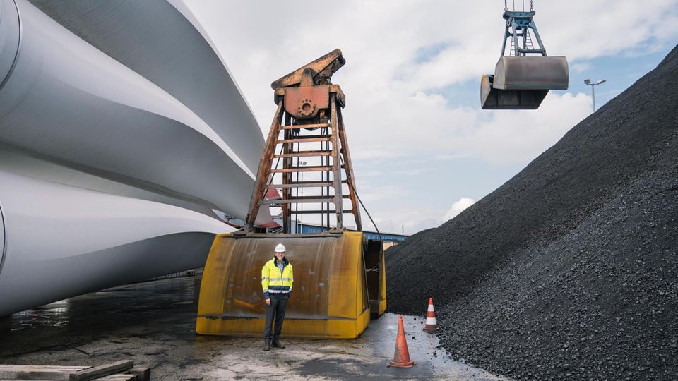 Frank Schnabel zwischen Windkraftrotoren und Kohlehalde