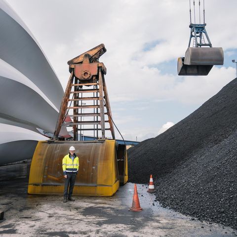 Frank Schnabel zwischen Windkraftrotoren und Kohlehalde