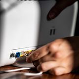 Eine Person zieht einen Stecker aus einem Router