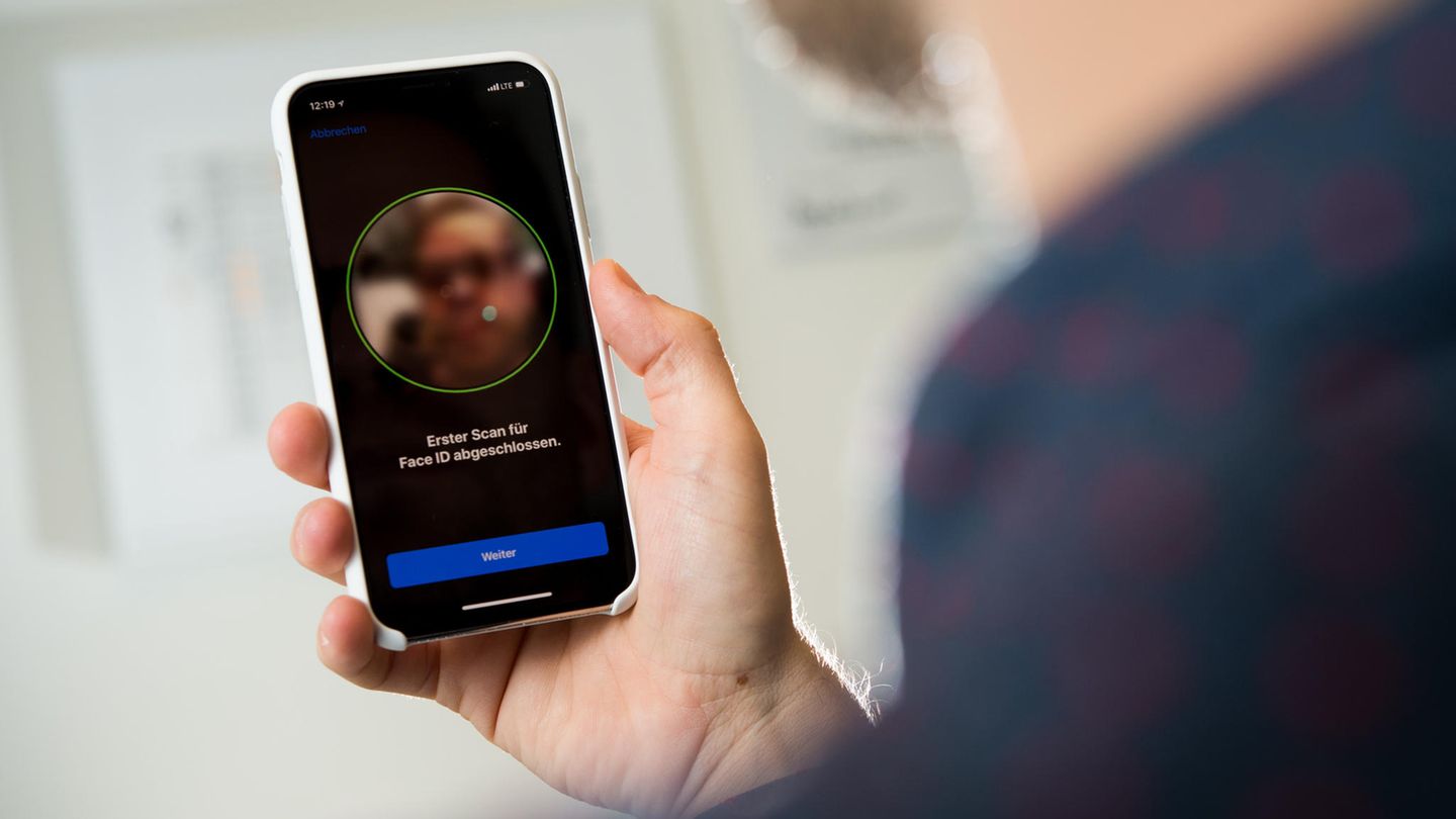 Ein Mann entsperrt sein Telefon mit seinem Gesicht Ein Mann entsperrt sein Telefon mit seinem Gesicht