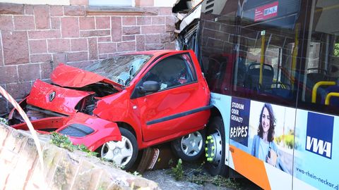 Heidelberg: Ein zerstörtes Auto und ein Linienbus stehen nach einem Unfall an einer Hauswand