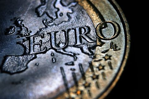 Eine Euromünze mit geprägtem Umriss des europäischen Kontinents und geriffeltem Rand liegt auf schwarzem Untergrund