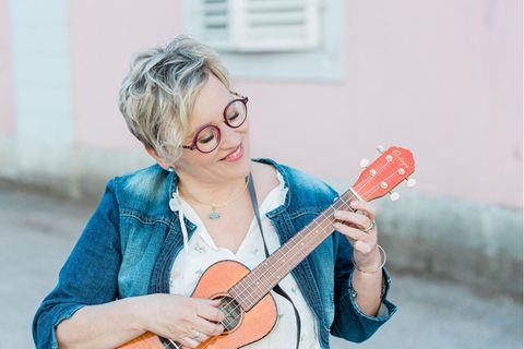 Trauersängerin Petra Berghaus spielt auf einer Ukulele