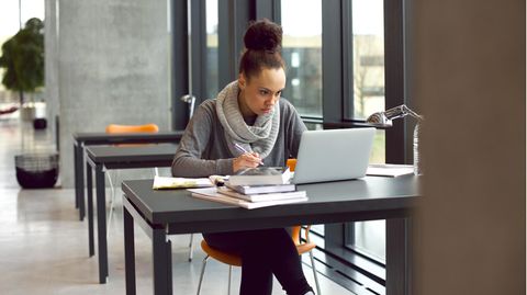 Laptop 13 Zoll: Eine Frau sitzt in der Universitätsbibliothek an einem 13-Zoll-Laptop.