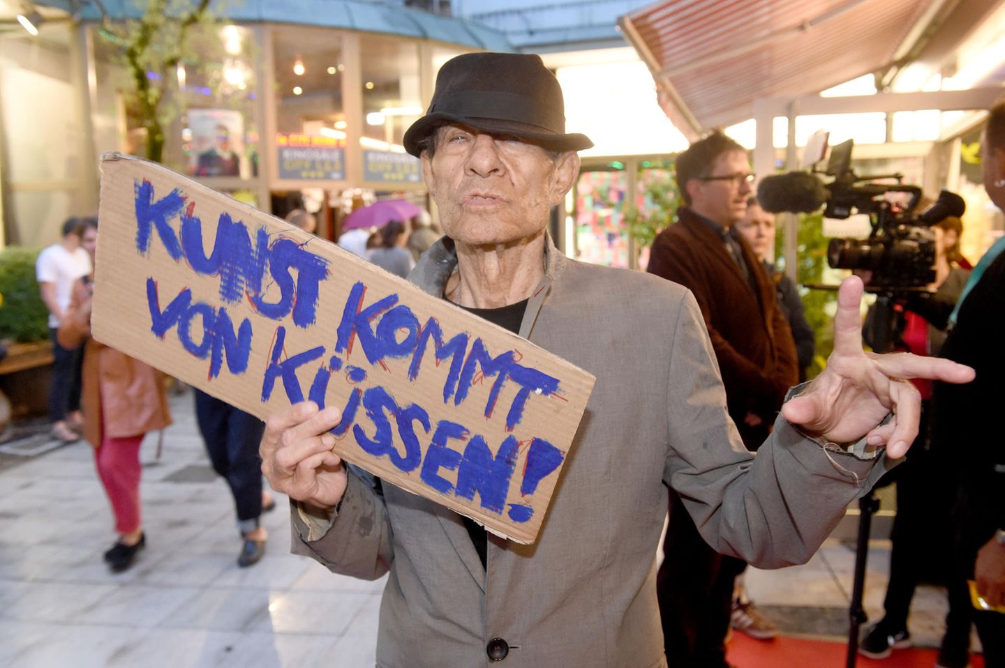 Ein Kino, das gesellschaftliche Probleme thematisiert, war ihm immer ein Graus: Klaus Lemke ging es um Freiheit, Lebenslust und um Sinnlichkeit - wie er hier auf diesem Schild demonstriert. In seinen Filmen spielten Liebe und Sex immer eine Rolle, aber auch Gewalt und Gefahr. Ganz nach dem Motto von Jean-Luc Godard: "Alles, was man für einen Film braucht, ist ein Revolver und ein Mädchen."