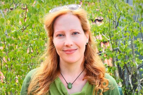 Sarah Benz, Bestatterin, Trauerbegleiterin und Notfallseelsorgerin, steht in einem Garten