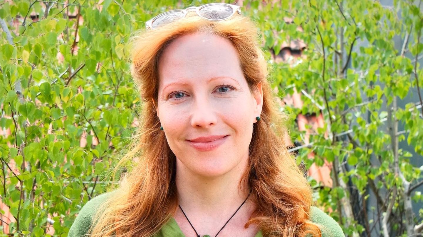 Sarah Benz, Bestatterin, Trauerbegleiterin und Notfallseelsorgerin, steht in einem Garten
