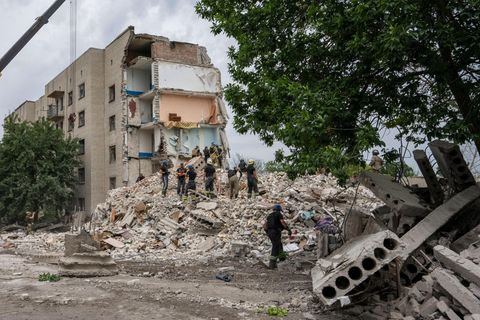 Rettungskräfte stehen auf den Trümmern eines Wohnblocks nach einem Raketeneinschlag in der Region Donezk in der Ostukraine
