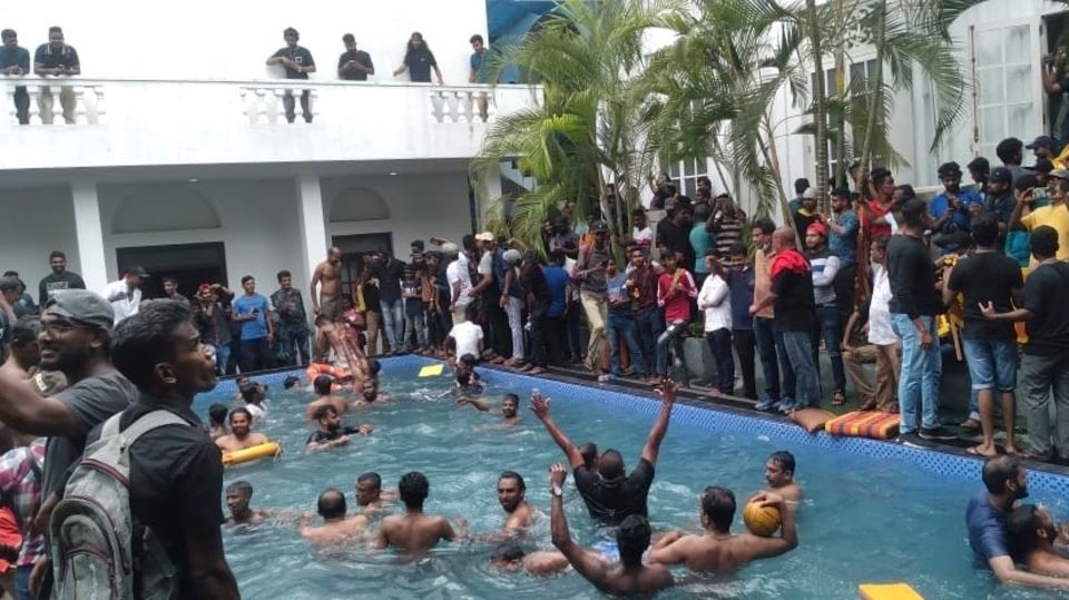 Anti-government opponents swim in a swimming pool at the Sri Lankan President's official residence