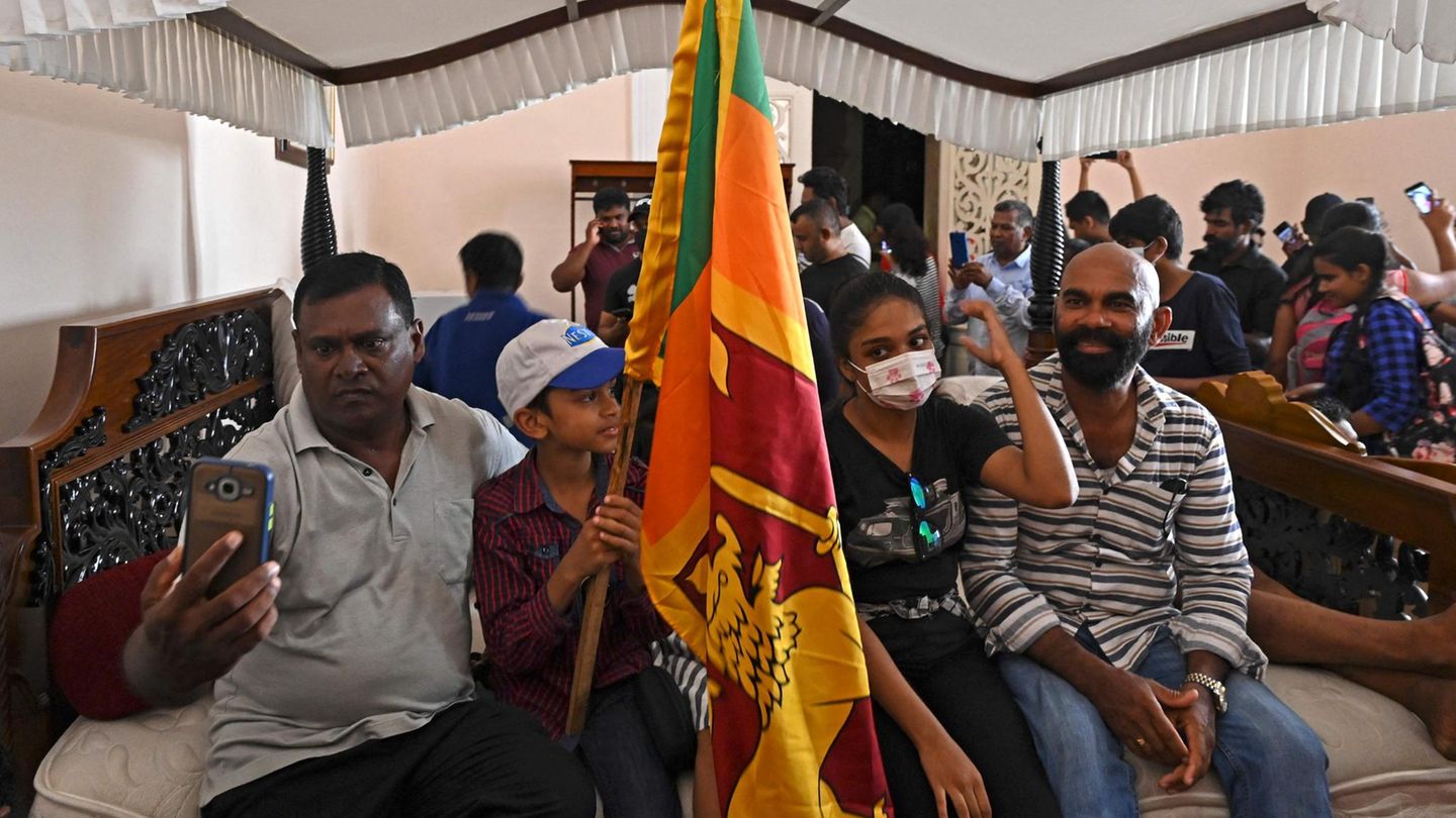 Mit einer sri-lankanischen Flagge haben sich Demonstranten auf ein Bett gesetzt